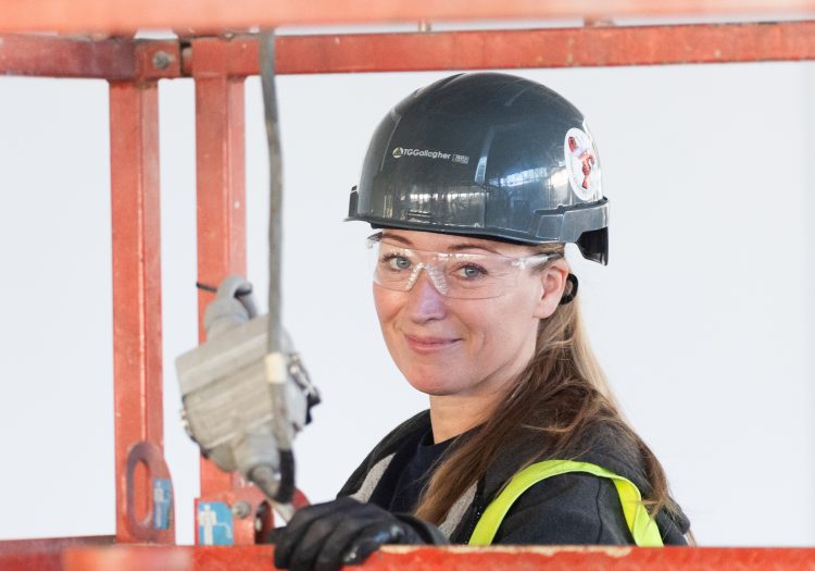 Women working on a construction site, wearing equipment