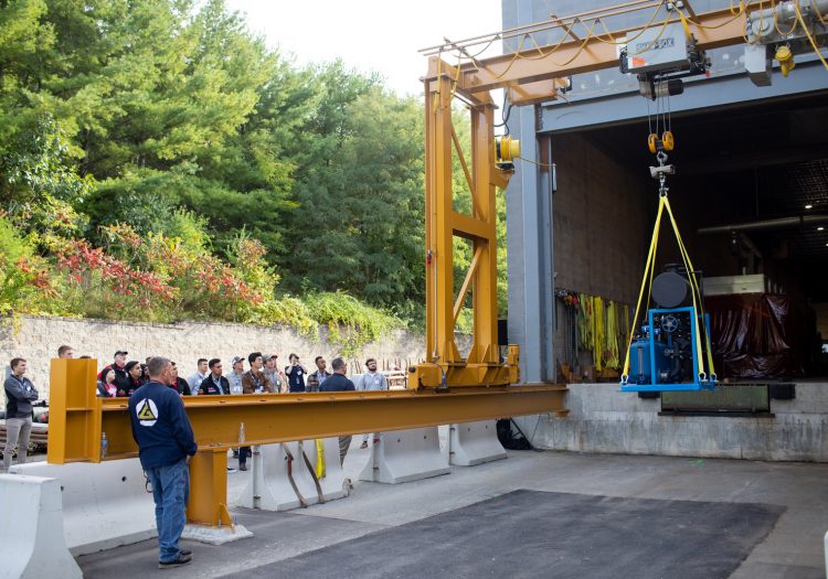 Group of people watching machinery being moved