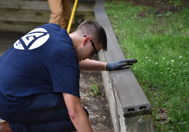 Man kneeling on the ground and helping with a garden