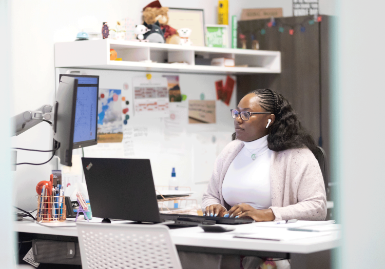 Woman typing on a computer at her desk