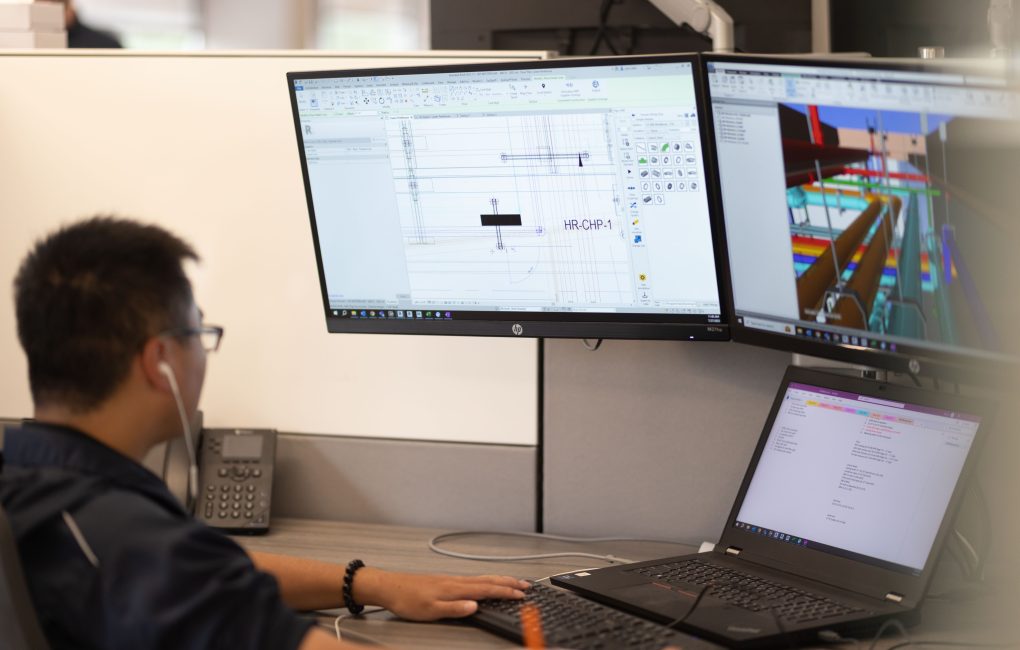 Man looking at computer screens, working with Building Information Modeling technology