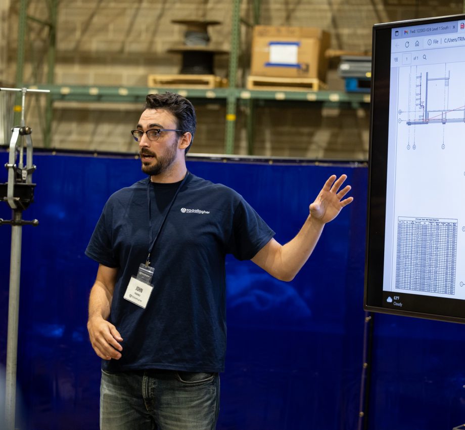 Man talking about a picture on a TV screen next to him